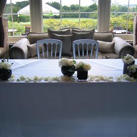 fwthumbClusters of black vases with white flowers and white rose petals. Registrar's table at Waterton.jpg
